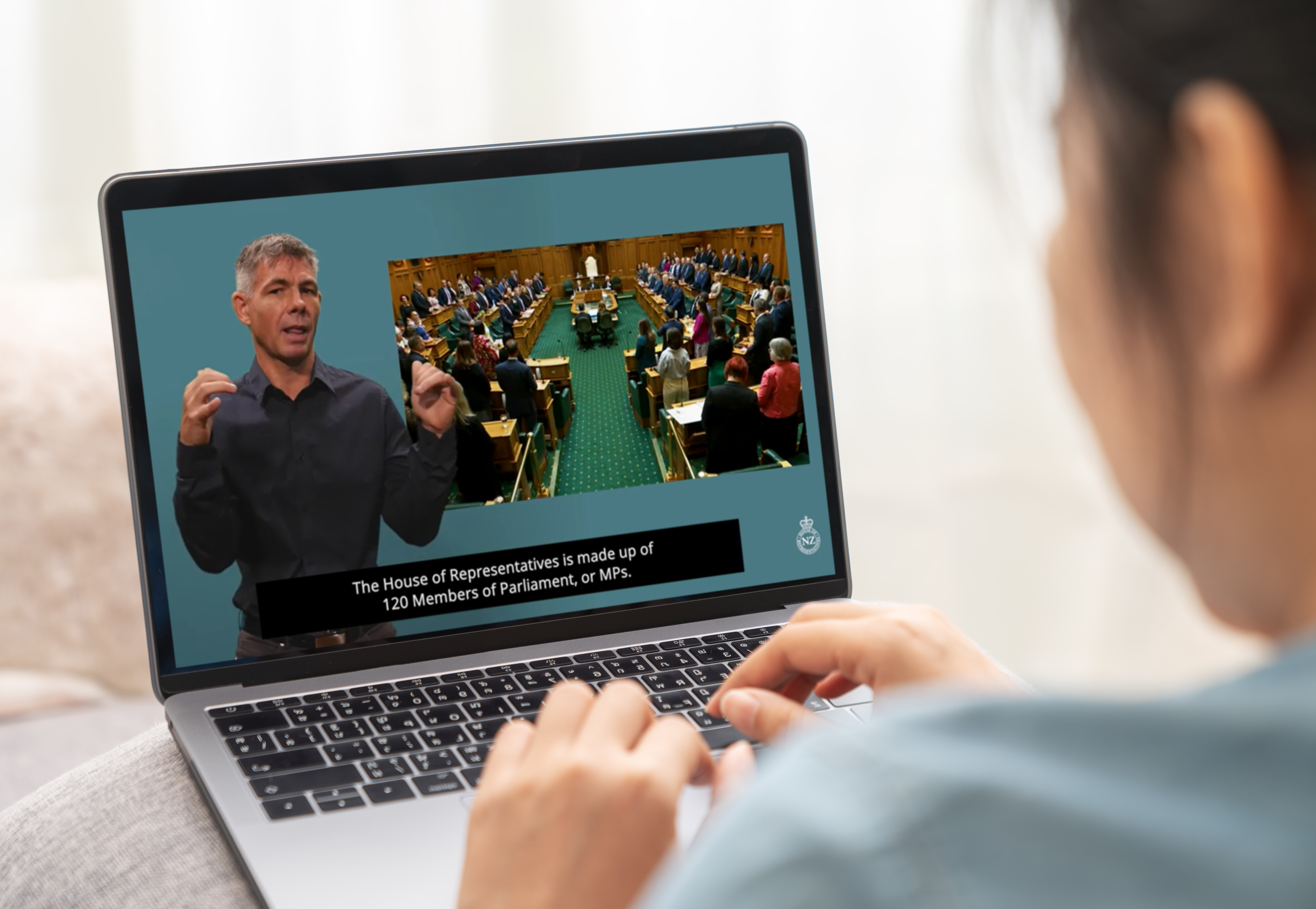 A woman watches “Parliament 101: How Parliament works” in NZSL.